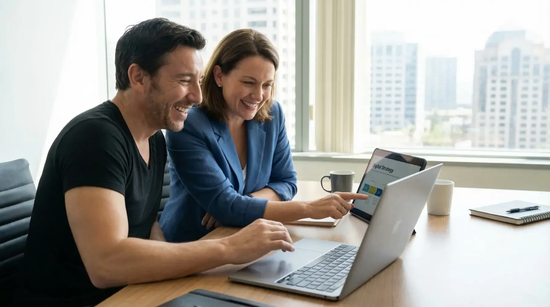 Chris Good going through a digital strategy with a client, both looking at a laptop